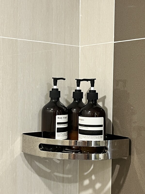 A bathroom shelf with two bottles of body wash and shampoo. - The Vineyard at Merlot TwinLakesTagaytay (Laurel)