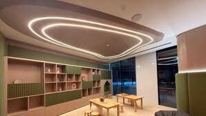 A modern interior with a curved ceiling, built-in shelving, and a seating area with a table and chairs. - Exclusive Apartment w Private Pool  (Dubai)