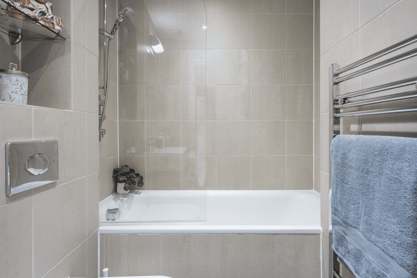A modern bathroom with a shower, a bathtub, and a towel rack.