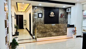 A reception area with a marble reception desk, a ceiling fan, and a sign for "The Ravishya Retreat." - The Ravishya Retreat (Ayodhya)