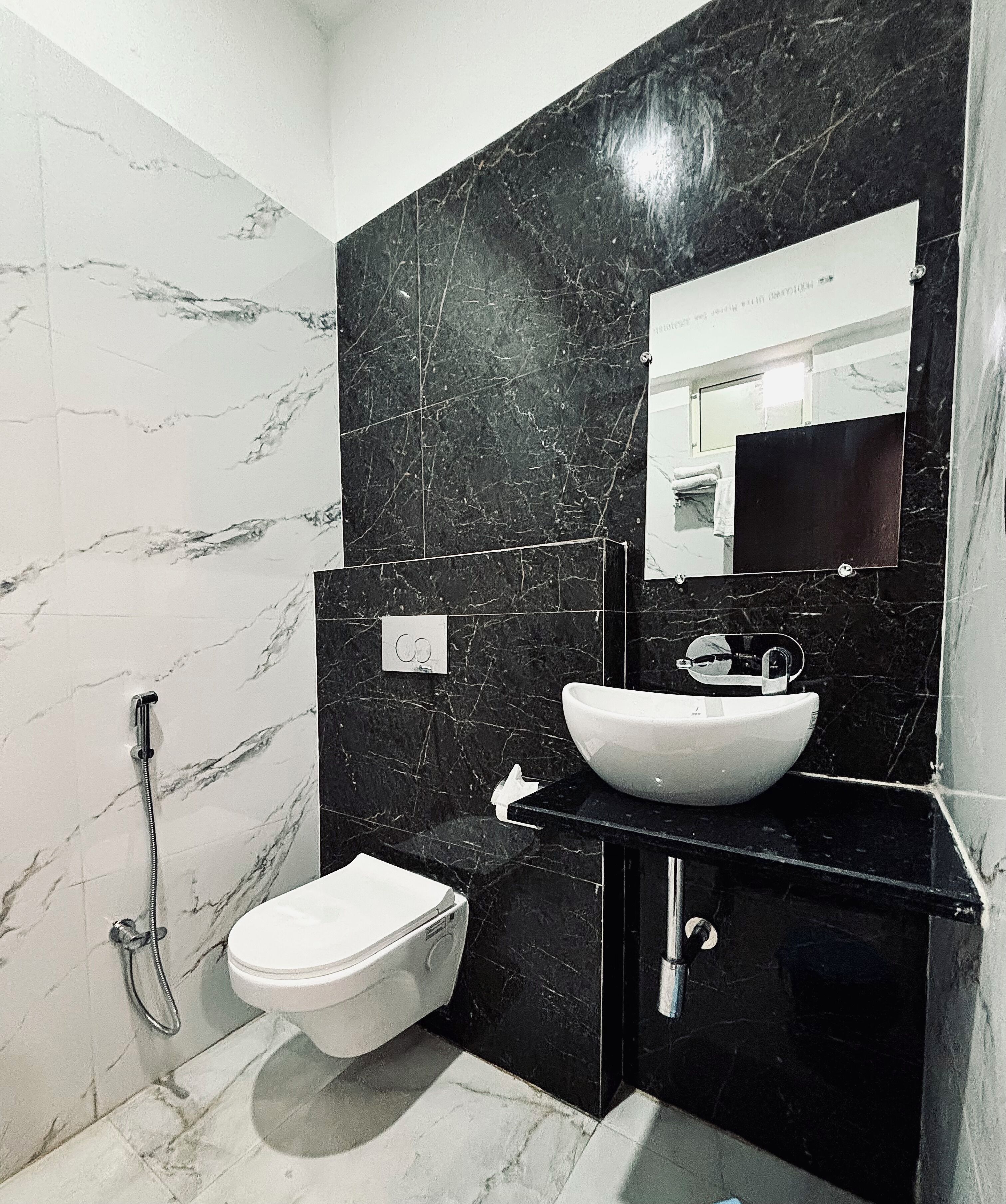 Une salle de bain avec des toilettes blanches, un lavabo blanc et une douche.