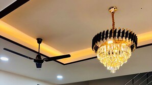 A dining area with a chandelier, a ceiling fan, and a staircase. - The Ravishya Retreat (Ayodhya)