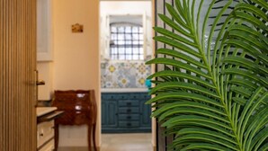 Una cocina con armarios azules, una silla de madera y una planta en maceta.