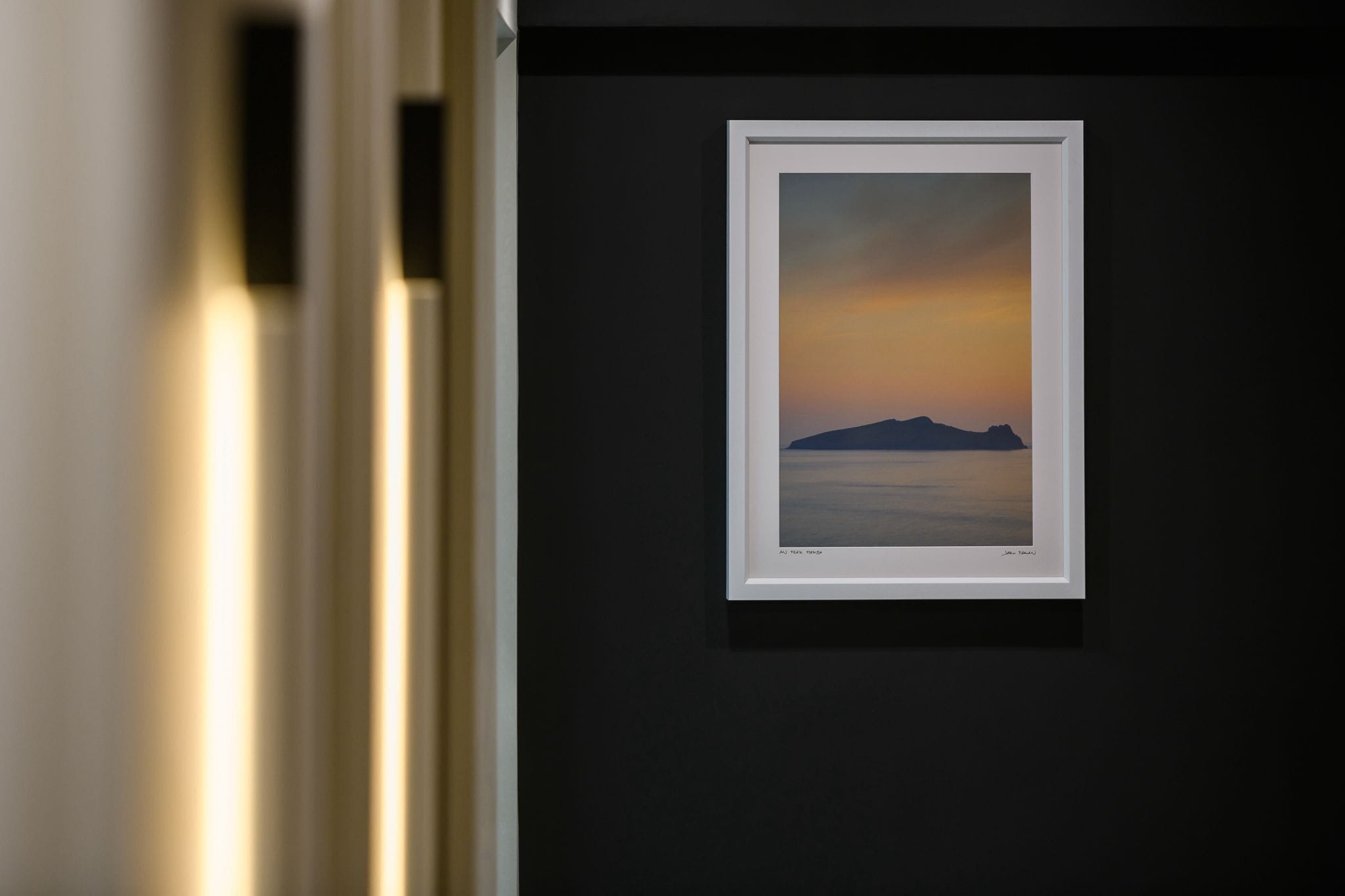 A framed artwork on a dark wall.