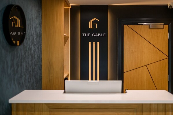A reception desk with a sign reading 'THE GABLE' and a logo above it. - The Gable Dingle (Dingle)