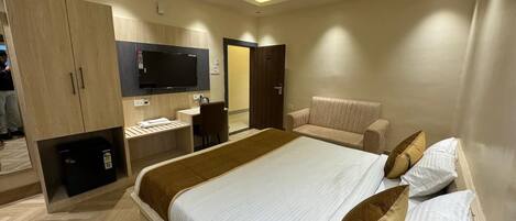 Una habitación de hotel moderna con una cama grande, un escritorio y un armario.