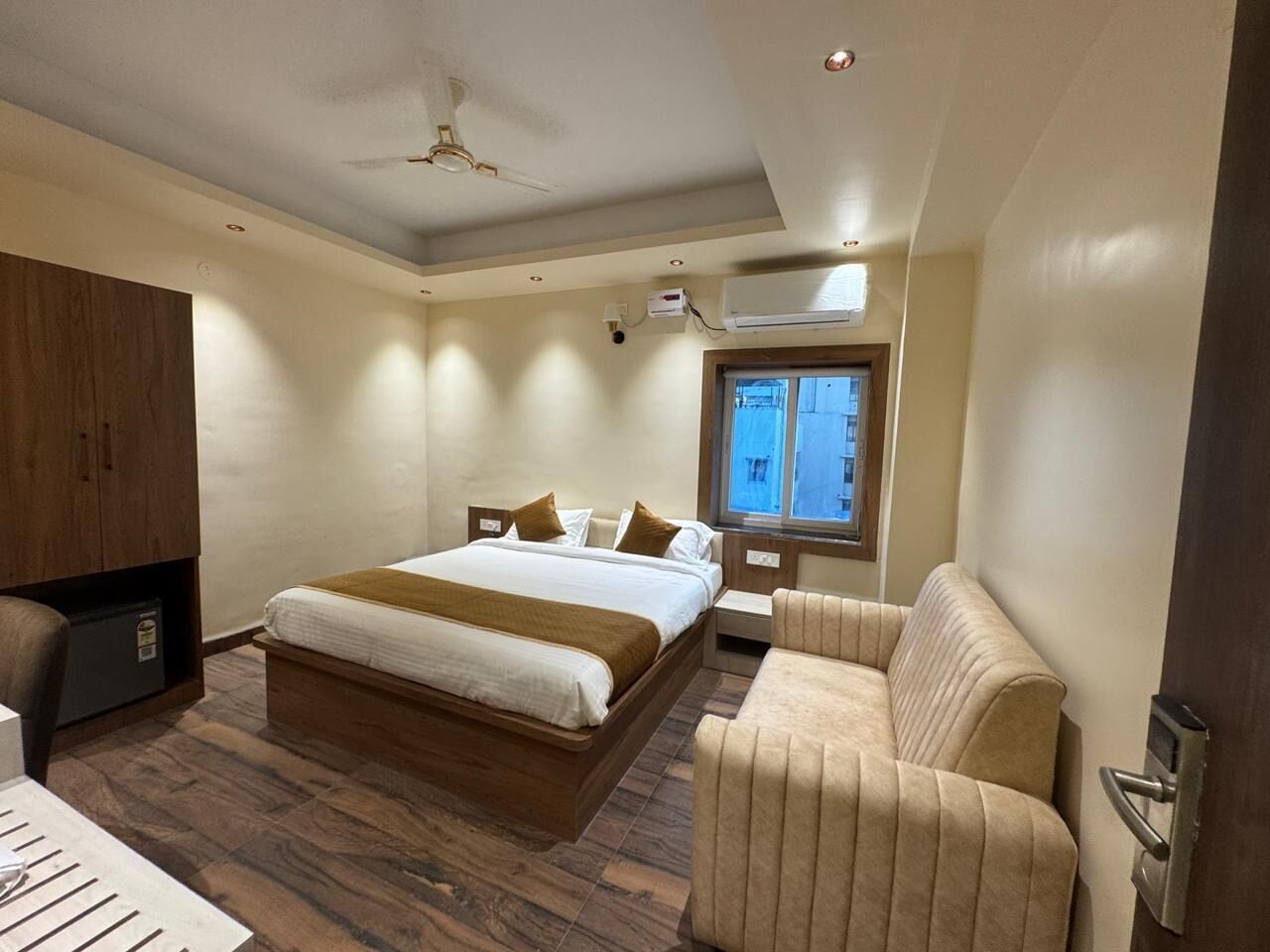 Una habitación de hotel con cama, sofá, escritorio y armario.