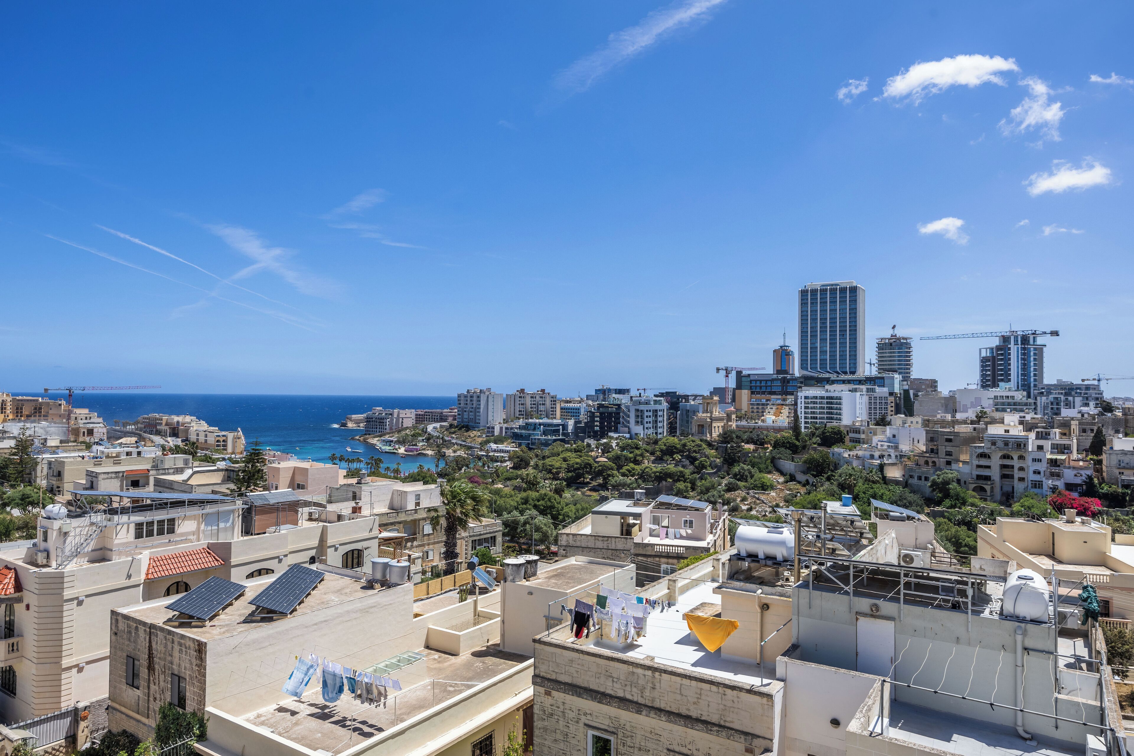 Un paisaje urbano con vista al mar, edificios y un cielo despejado.