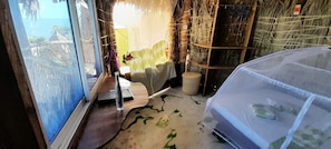 A room with a bed, a window, a straw wall, and a view of the ocean. - Eliye Springs Resort (Eliye)