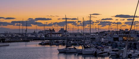 A marina filled with various boats at sunset.