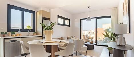 A modern kitchen with a dining area, a round table, and chairs.