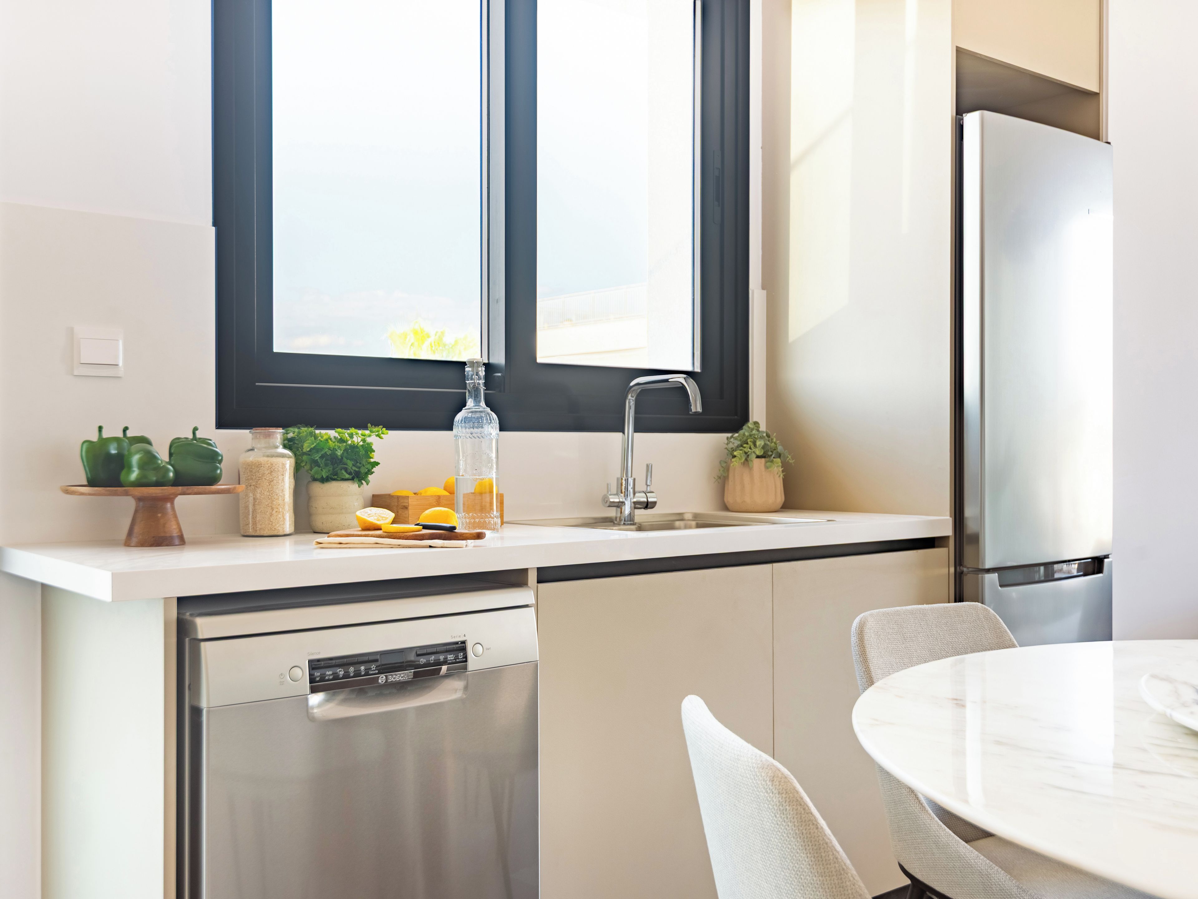 Een moderne keuken met een vaatwasser, spoelbak en een koelkast.