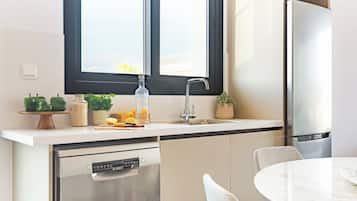 Een moderne keuken met een vaatwasser, spoelbak en een koelkast.