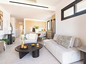 A modern living room with a sofa, coffee table, and a dining area in the background. - Sanders City Boutique - Full Building (Limassol)