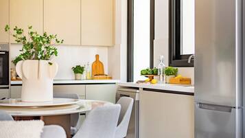 Una cocina moderna con comedor, que incluye una mesa redonda, sillas y una planta en maceta.