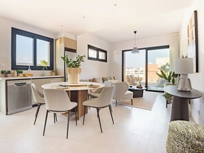 A modern kitchen with a dining area, a round table, and chairs. - Sanders City Boutique - Full Building (Limassol)