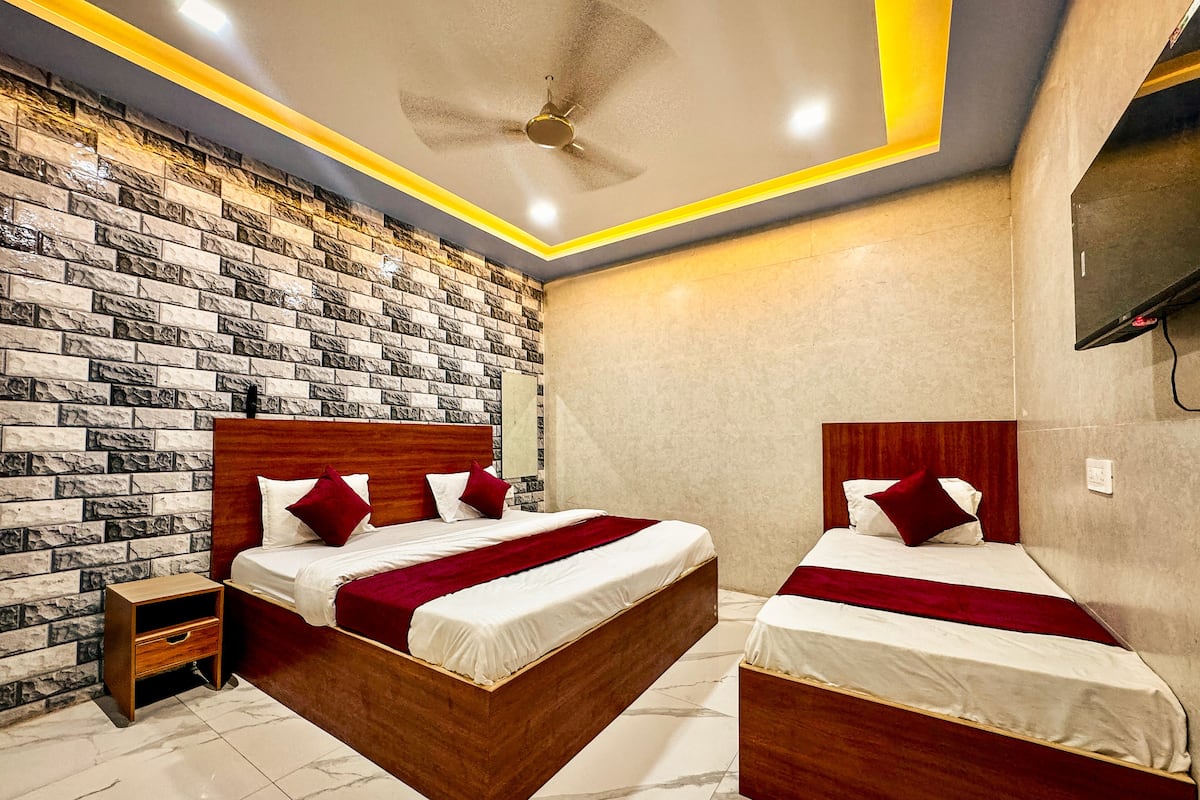 A hotel room with two beds, a wooden headboard, a marble floor, and a brick-patterned wall.