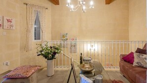 Un salon chaleureux avec un lustre, une table à manger et une plante en pot.