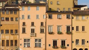 Une rangée d’immeubles à plusieurs étages, dotés de balcons et de fenêtres en arc de cercle.