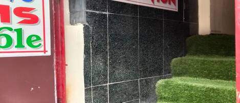 A reception area with a sign indicating 'J.J RECEPTION' above a staircase with artificial grass steps.
