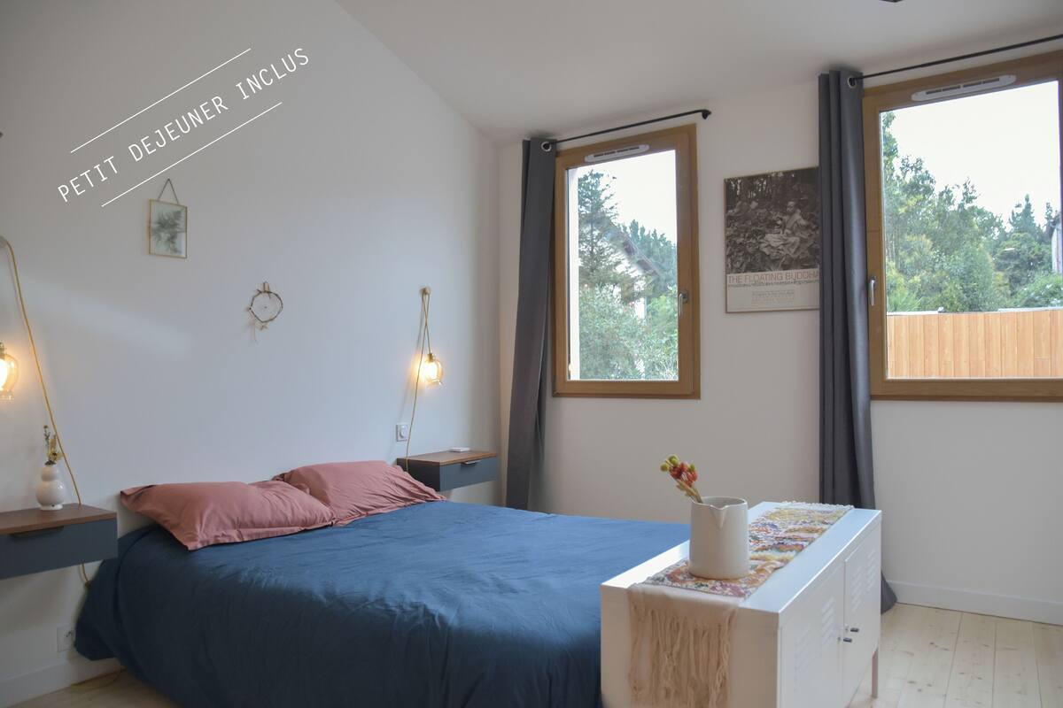 A bedroom with a bed, bedside tables, a dresser, and a window with curtains.
