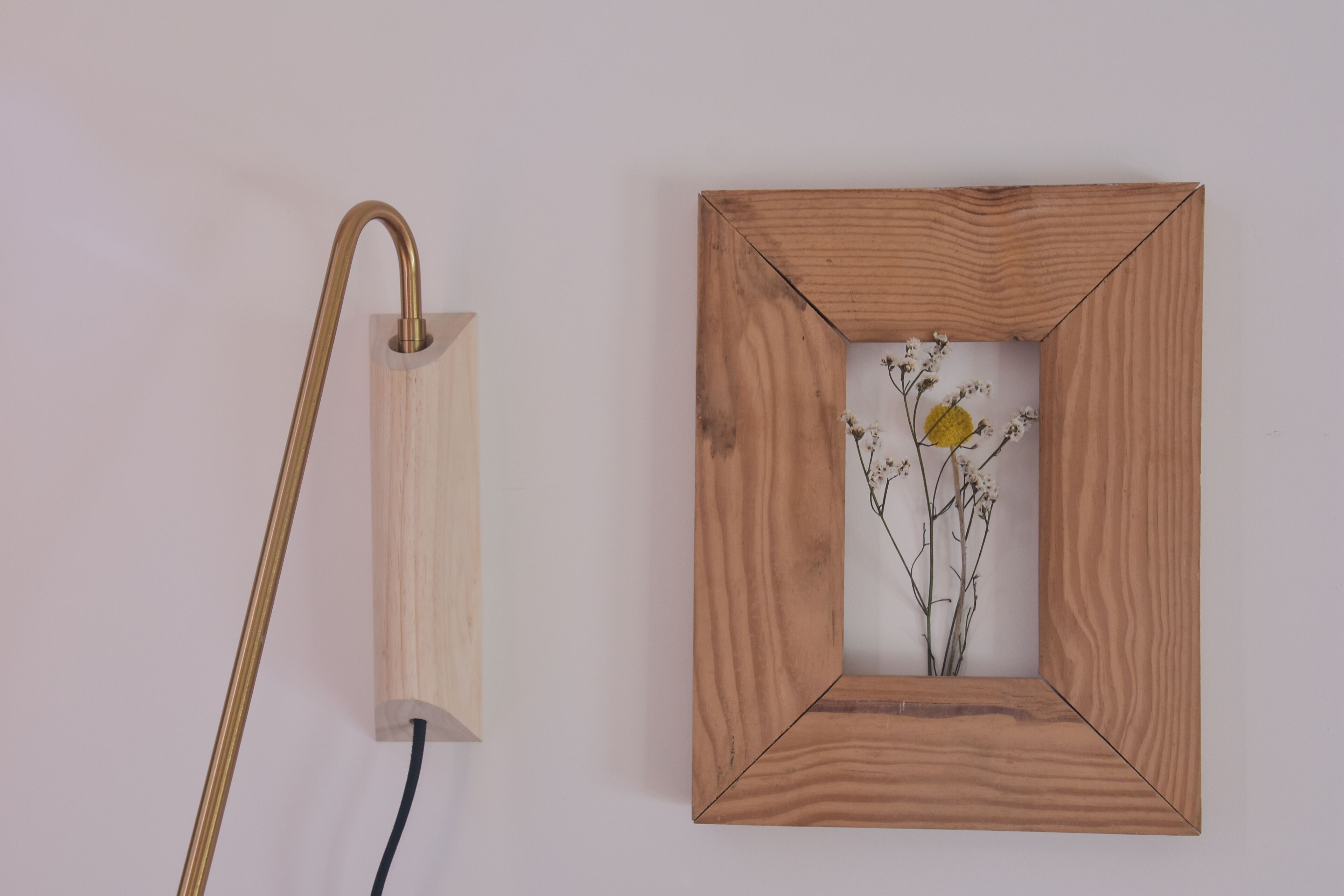 Un cadre en bois avec une image de fleurs accrochée au mur.