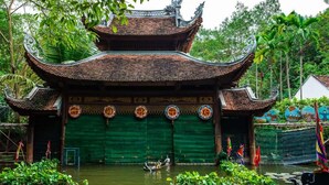A traditional building with a tiled roof and a green door, surrounded by water and plants. - Seréne - Old Quarter Centre Hotel Ha Noi (Hanoi)