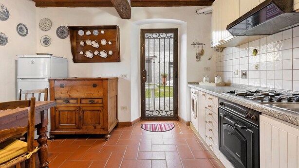 A kitchen with a stove, oven, and wooden cabinets. - Casa Relax in the Countryside (Pomino)