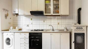 A kitchen with white cabinets, a stove, a dishwasher, and a built-in oven.