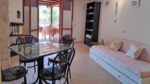 Um espaço compacto com área de jantar, sofá e estante.