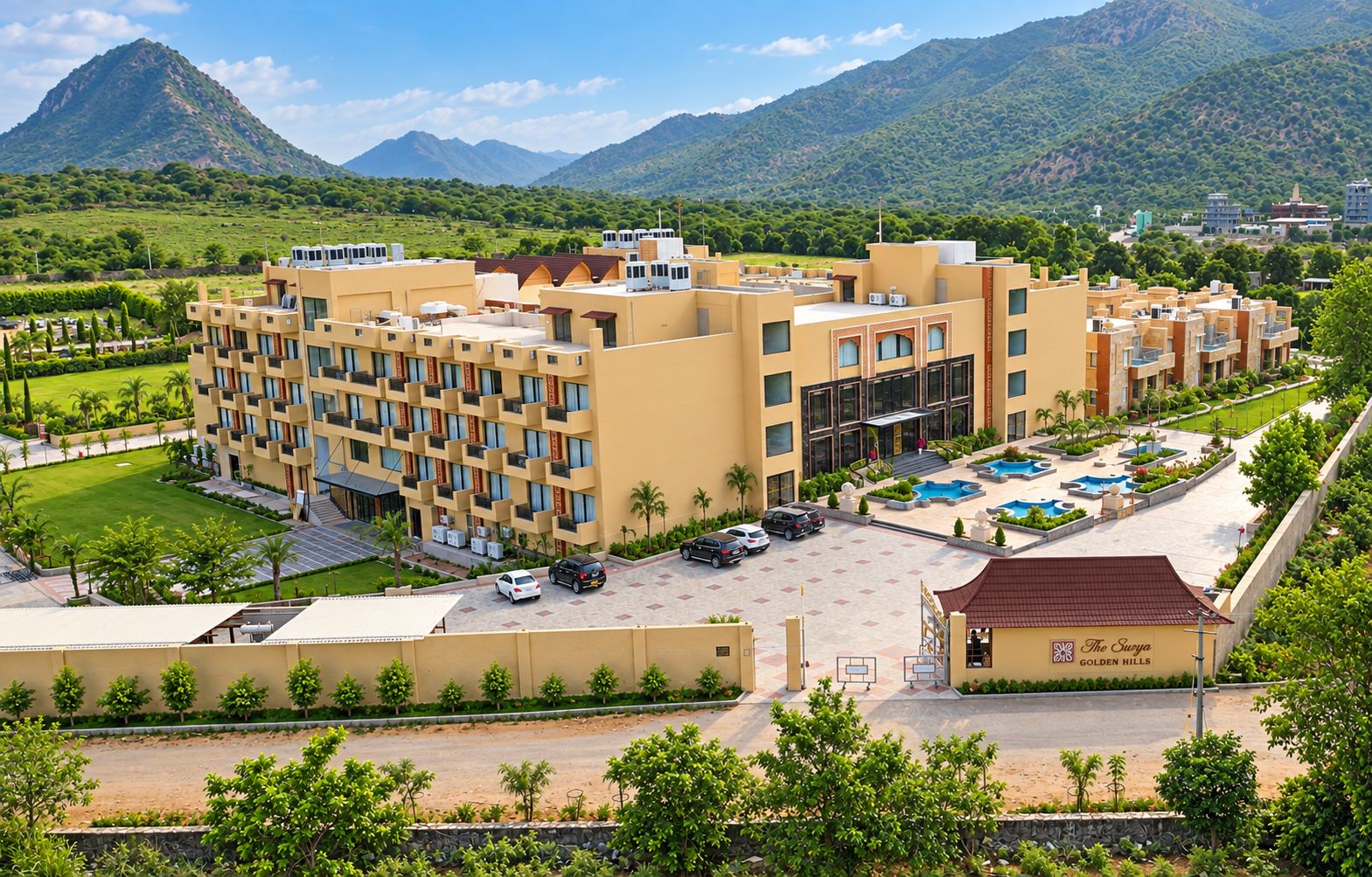 A hotel with multiple floors, a swimming pool, and a mountainous backdrop.