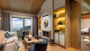 Paris Suite | Woonruimte | Een 55-inch smart-tv met satellietzenders, een open haard en boeken