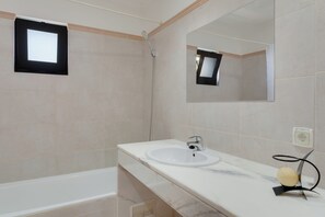 A bathroom with a white sink, a mirror, and a shower. - Andrade's Villa by HRM (Santa Cruz)