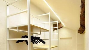 Une chambre avec des lits superposés, un plancher en bois et un mur blanc.