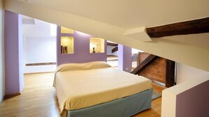 Une chambre à coucher avec un lit, des poutres en bois et un escalier.