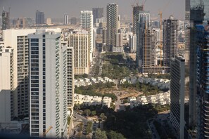 A high-rise building with multiple floors, surrounded by other tall buildings and construction cranes. - Exclusive High-Floor Apartment  (Dubai)