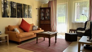 Ein Wohnzimmer mit einer Couch, einem Couchtisch und einem Bücherregal.