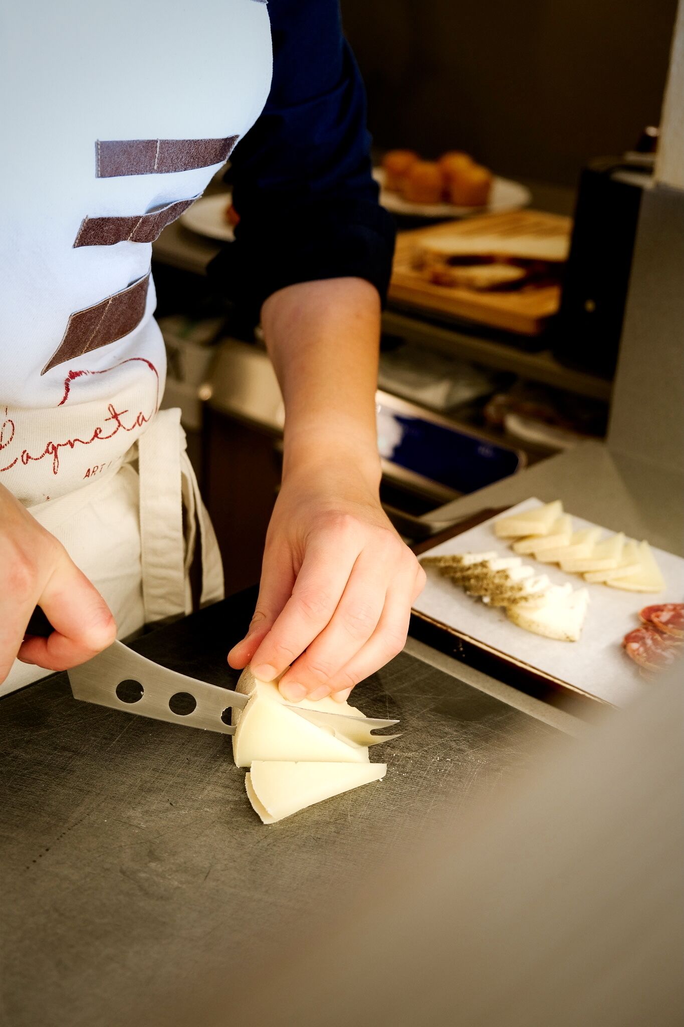 A person cutting cheese on a cutting board.