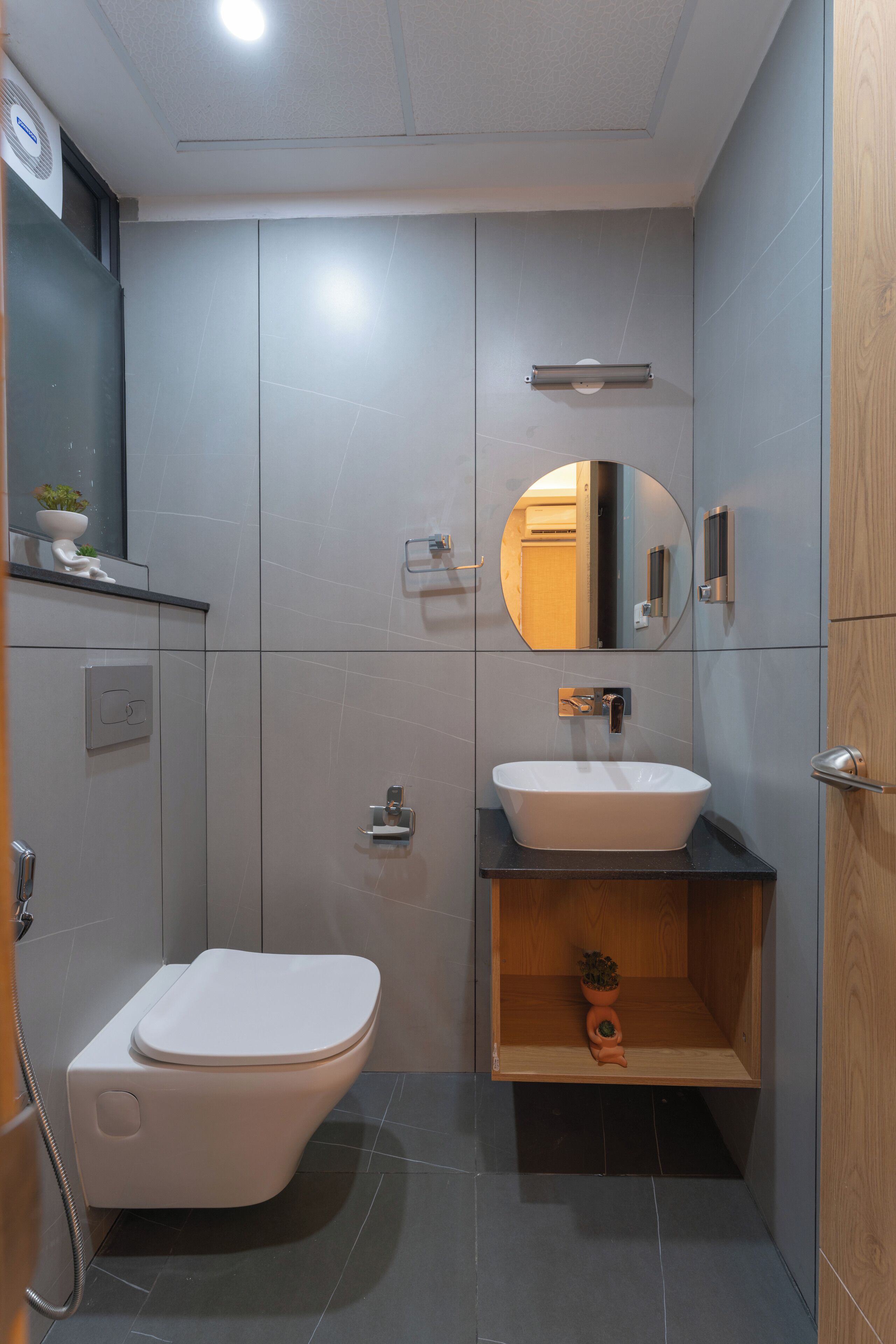 Un bagno moderno con il water, un lavandino e uno specchio.