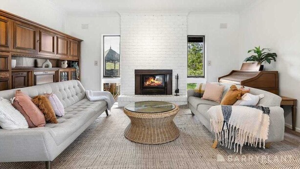 Un salon moderne avec une cheminée, deux canapés, une table basse et des meubles en bois.