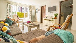A modern living room with a sofa, armchairs, a coffee table, and a TV. - Villa Catrina - Plusholidays (Calpe)