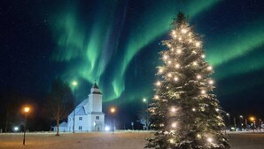 A snow-covered landscape with a lit Christmas tree and a church. - Room-room With Bathroom in Bardu (Bardu)