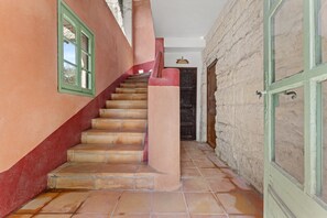 Un escalier avec une rampe rouge menant à une porte en bois.