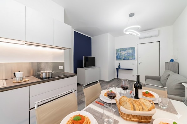 Une cuisine moderne avec un coin repas, un téléviseur à écran plat et un tableau accroché au mur.