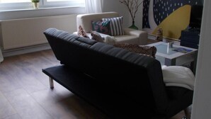 Una sala de estar moderna con un sofá, una mesa de centro y un cuadro en la pared.