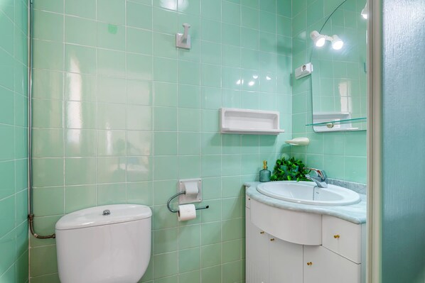 A bathroom with a toilet, sink, and mirror. - Villa Mercedes - Plusholidays (Calpe)