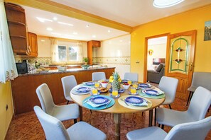 A dining area with a round table set for four, surrounded by chairs. - Villa Flora - Plusholidays (Calpe)