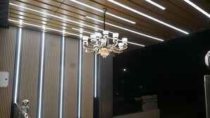 Ein modernes Interieur mit einer Chandelieber, vertikalen Lichtleisten und einem Schild.