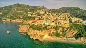 Une ville côtière avec des bâtiments construits sur une colline, dominant une mer bleue et limpide.