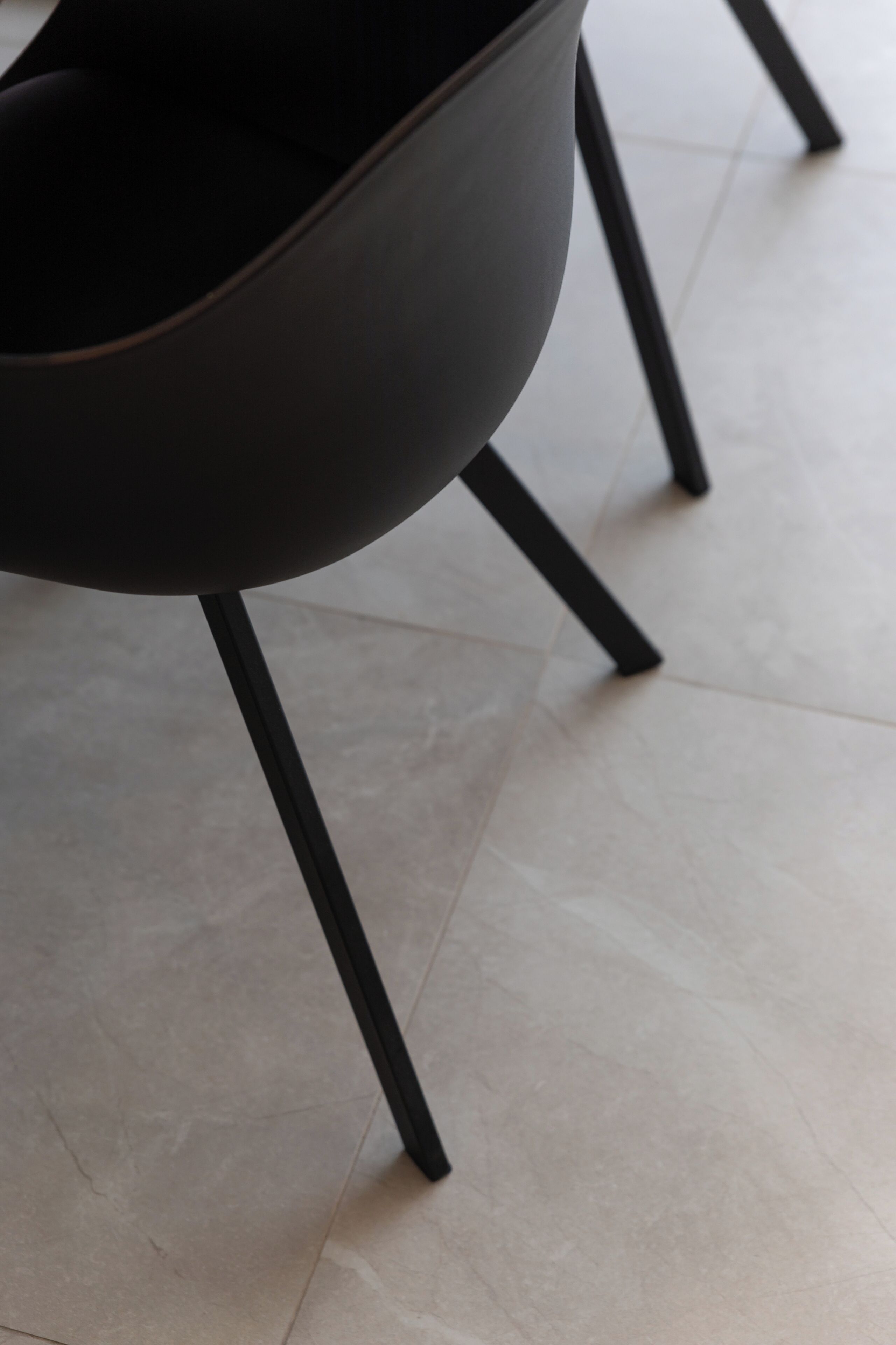 A modern chair with a curved backrest and black metal legs.